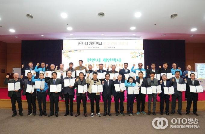 김석필 천안시장 권한대행 부시장이 23일 시청 대회의실에서 열린 개인택시 신규면허 교부식에서 대상자 29명과 함께 안전운전을 다짐하며 기념촬영을 하고 있다.